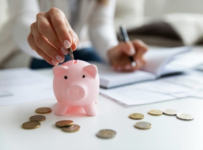 woman puts coins in piggybank